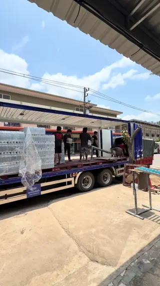 รถพ่วงบรรทุกน้ำดื่มเต็มคันจอดอยู่หน้าร้าน